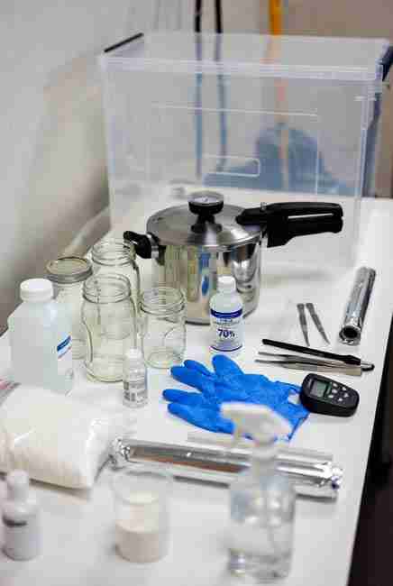 Beginner sterile lab materials for cannabis tissue culture micropropagation including pressure cooker, mason jars, nitrile gloves, 70% isopropyl alcohol, bleach, distilled water, agar powder, pH meter, and tools sterilized at 15 psi for home cannabis genetics preservation