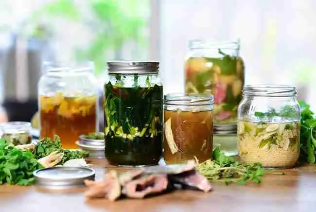 Glass jars of KNF fermented plant juices, fish hydrolysate, and brown rice vinegar recipes for cannabis