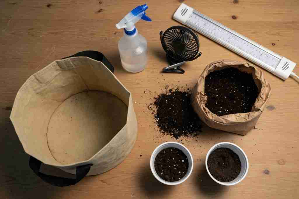 Simple beginner cannabis starter kit with fabric pot, soil, spray bottle, fan, and LED bar