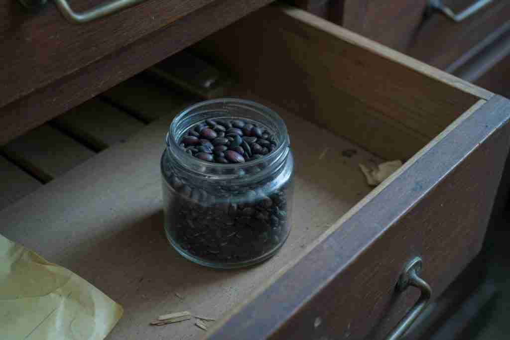 A jar of seeds in a wooden drawer