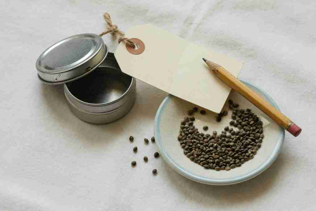 A blank tag and a tin beside a dish of cannabis seeds
